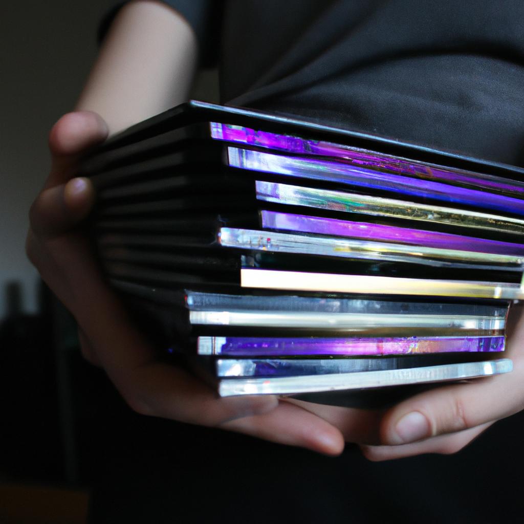 Person holding stack of DVDs